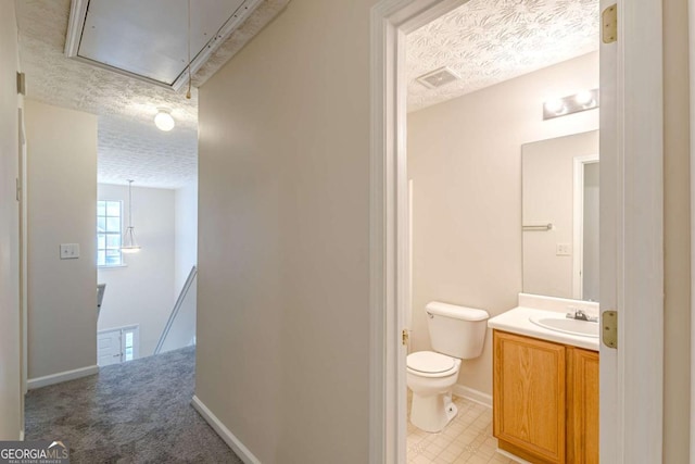 bathroom with vanity, a textured ceiling, and toilet