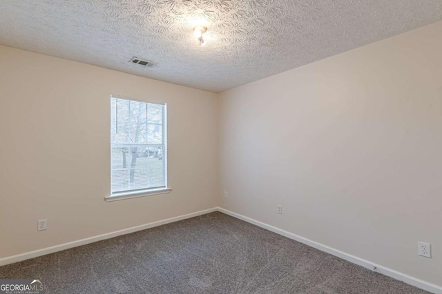 carpeted spare room featuring a textured ceiling