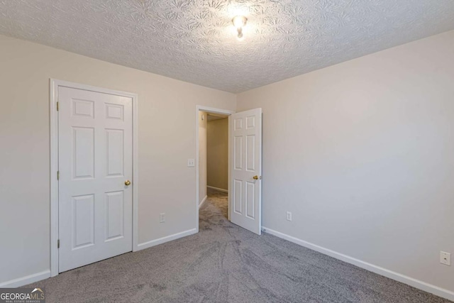 unfurnished bedroom featuring carpet and a textured ceiling