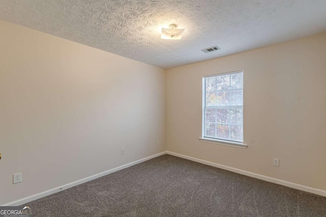 carpeted empty room with a textured ceiling