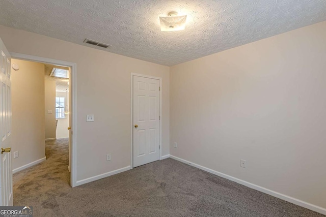 unfurnished bedroom featuring a textured ceiling and carpet floors