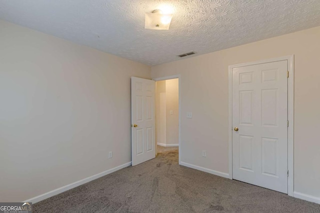 unfurnished bedroom featuring carpet flooring and a textured ceiling