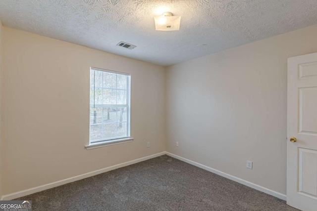 carpeted spare room with a textured ceiling