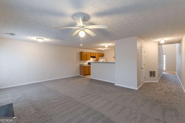 unfurnished living room with carpet, ceiling fan, and a textured ceiling