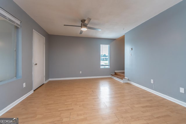 empty room with ceiling fan and light hardwood / wood-style floors