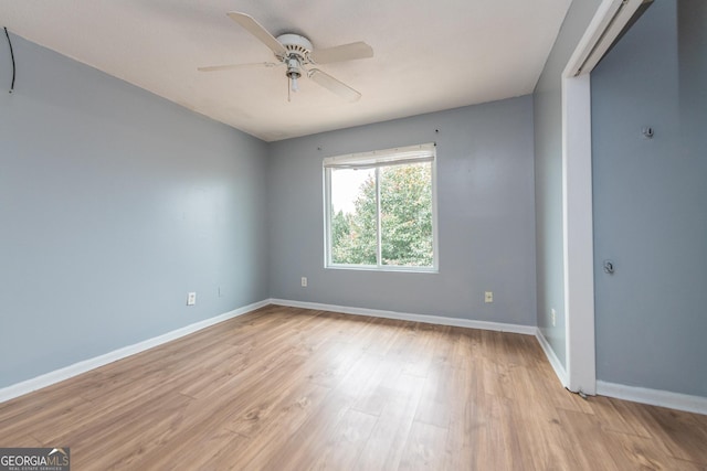 empty room with ceiling fan and light hardwood / wood-style flooring