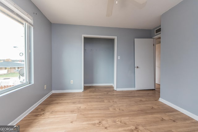 unfurnished bedroom with ceiling fan, a closet, and light hardwood / wood-style flooring