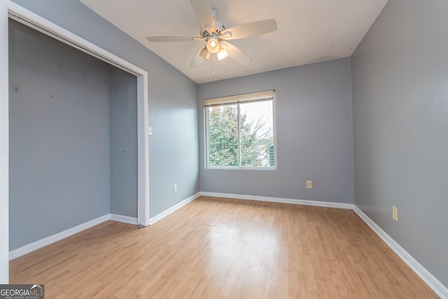 empty room with ceiling fan and light hardwood / wood-style floors