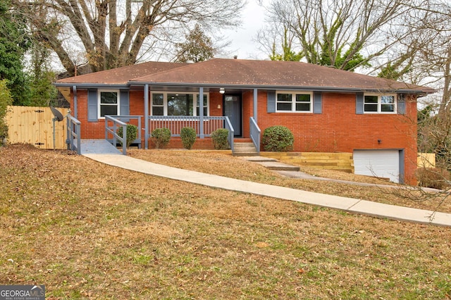 ranch-style house featuring a garage, covered porch, and a front lawn