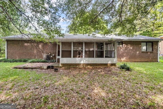 back of property with a sunroom and a yard