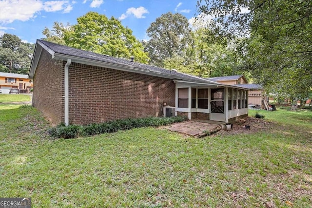 rear view of house featuring a lawn, cooling unit, and a sunroom