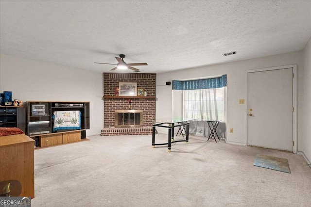 living room with a fireplace, carpet, a textured ceiling, and ceiling fan