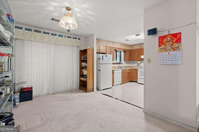 kitchen featuring white appliances, sink, and exhaust hood