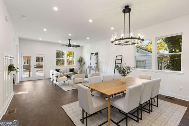 dining room with dark hardwood / wood-style floors and ceiling fan with notable chandelier