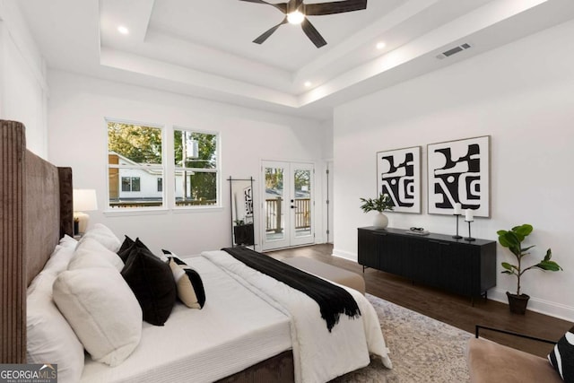 bedroom with a raised ceiling, access to exterior, ceiling fan, and wood-type flooring