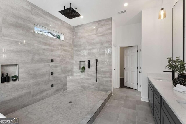 bathroom featuring tile patterned floors, vanity, and tiled shower