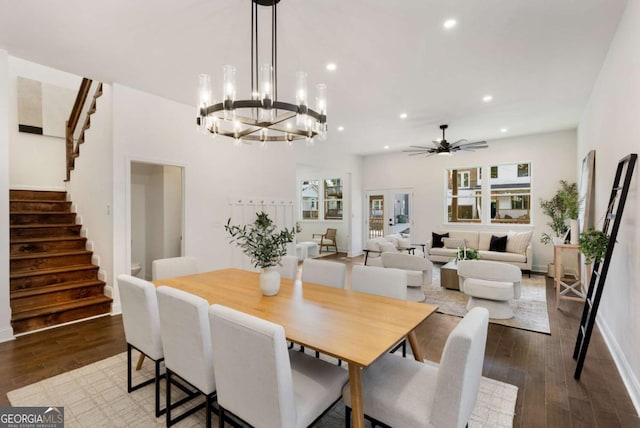 dining space featuring wood-type flooring and ceiling fan with notable chandelier