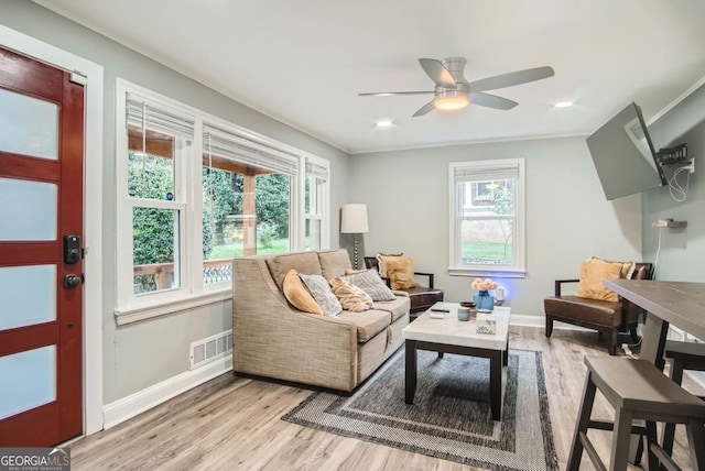 sitting room with light hardwood / wood-style flooring, a wealth of natural light, crown molding, and ceiling fan