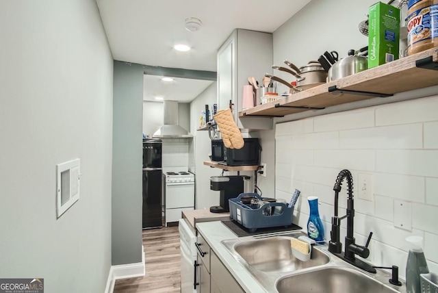 kitchen with sink, wall chimney exhaust hood, refrigerator, white stove, and light wood-type flooring