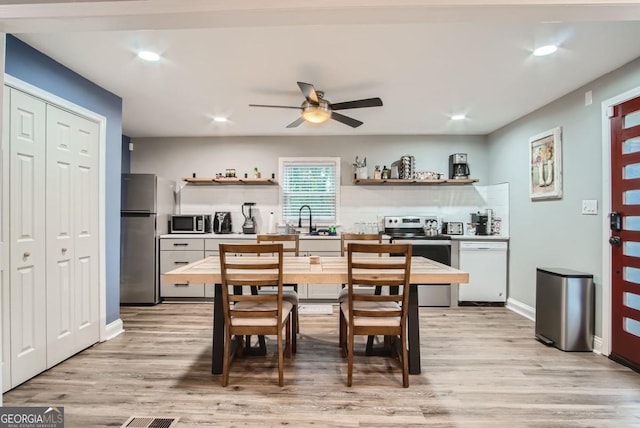 kitchen featuring ceiling fan, sink, stainless steel appliances, and light wood-type flooring