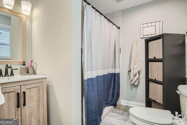 bathroom featuring wood-type flooring, vanity, toilet, and curtained shower