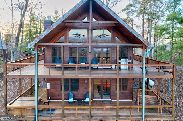 rear view of property with a sunroom, ceiling fan, and a balcony