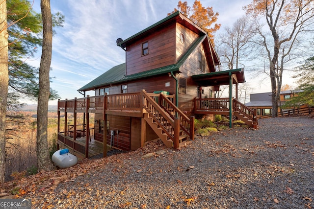 back house at dusk featuring a deck