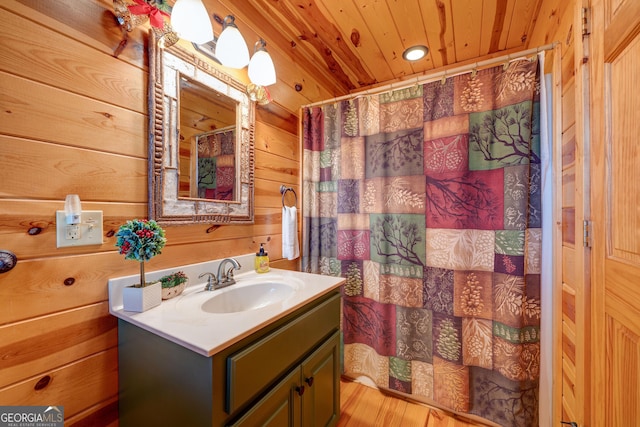 bathroom with wood-type flooring, vanity, wooden ceiling, and wood walls