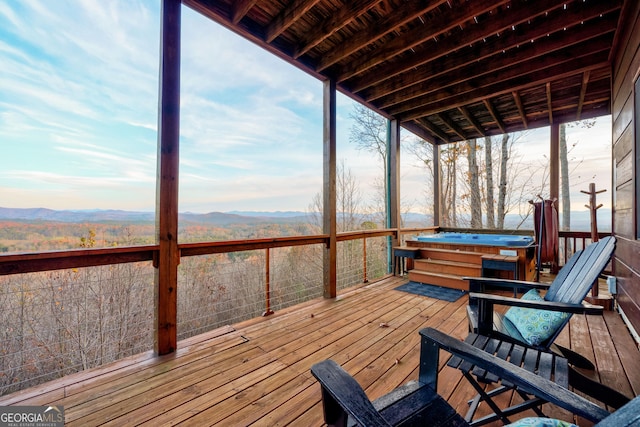 deck featuring a mountain view and a hot tub