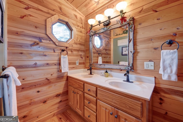 bathroom featuring hardwood / wood-style floors, vanity, vaulted ceiling, and wooden walls