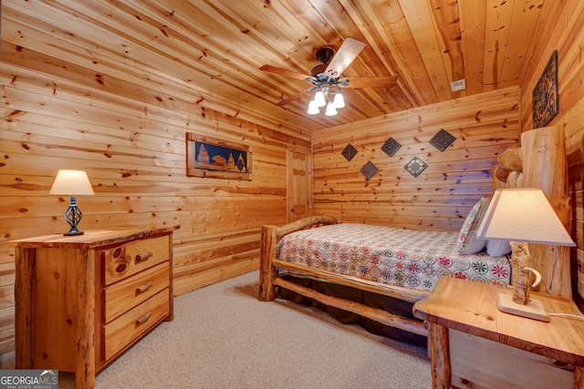 bedroom with ceiling fan, wood ceiling, light carpet, and wooden walls