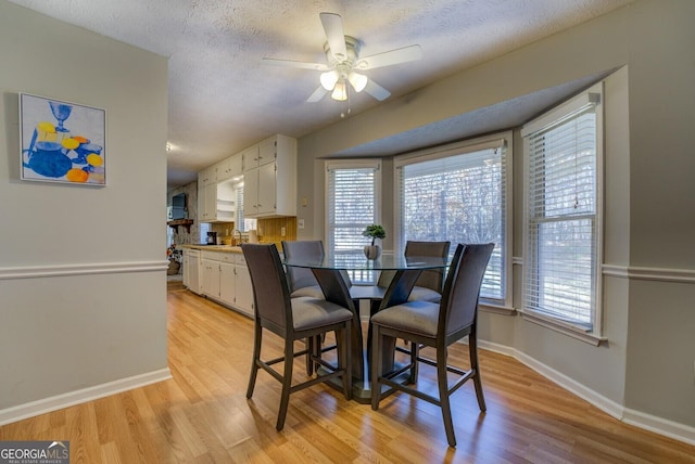 dining area featuring light hardwood / wood-style floors, ceiling fan, and a healthy amount of sunlight