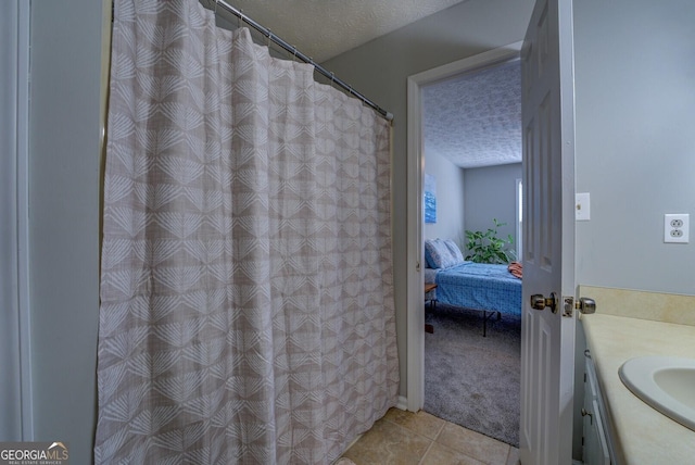 bathroom with vanity, a textured ceiling, and tile patterned floors