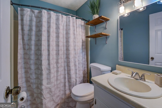 bathroom with vanity, a textured ceiling, and toilet