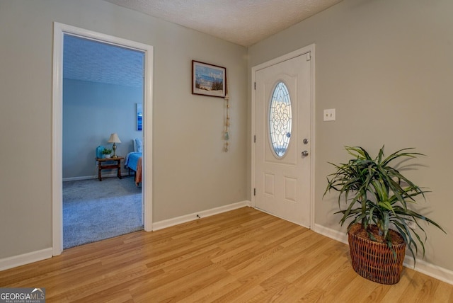 foyer featuring a textured ceiling and light wood-type flooring