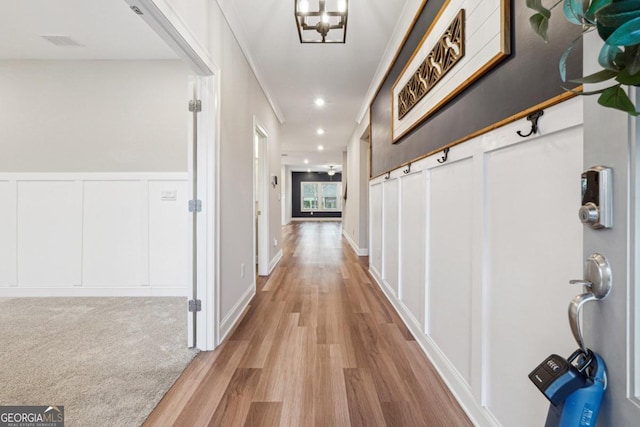 hallway featuring light hardwood / wood-style flooring and a notable chandelier