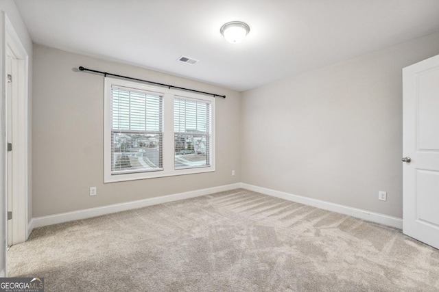 spare room featuring light carpet