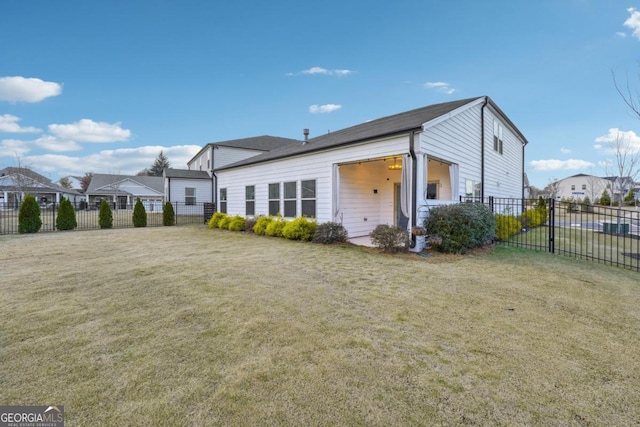 rear view of property featuring a lawn