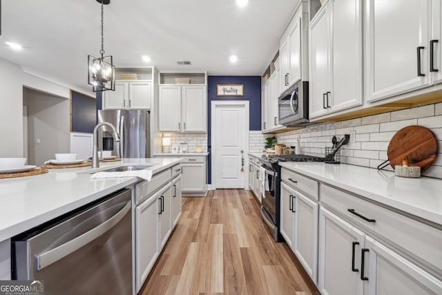 kitchen featuring light wood-type flooring, stainless steel appliances, and white cabinetry