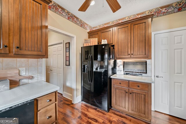 kitchen with a textured ceiling, black refrigerator with ice dispenser, ceiling fan, and dark hardwood / wood-style floors