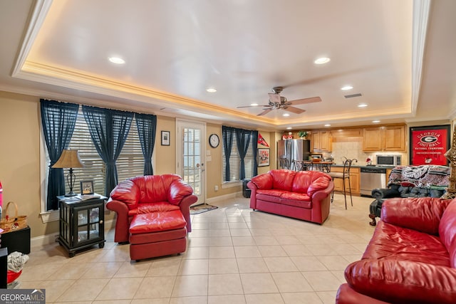 living area with a raised ceiling, ornamental molding, recessed lighting, light tile patterned floors, and ceiling fan
