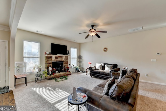 living room with a fireplace, ceiling fan, plenty of natural light, and carpet floors