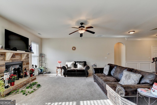 carpeted living room featuring ceiling fan and a fireplace