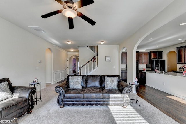 living room with ceiling fan and dark hardwood / wood-style flooring