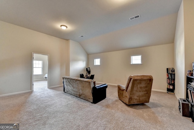 carpeted living room with vaulted ceiling