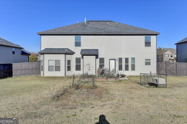 rear view of house featuring a yard