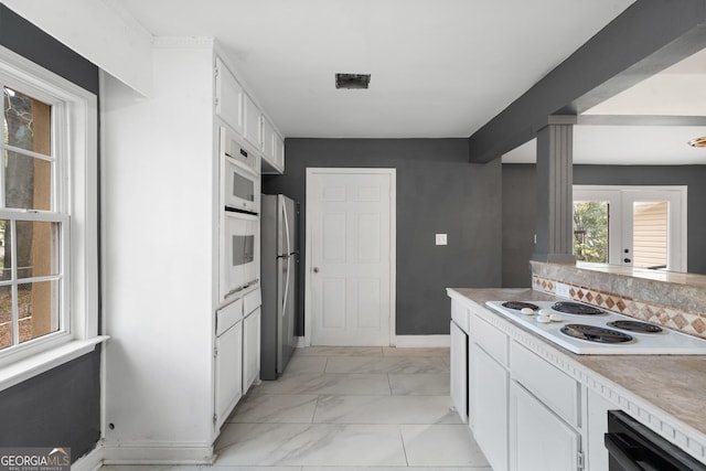 kitchen featuring white cabinets, french doors, and white appliances