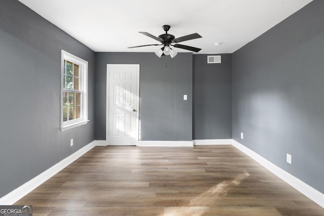 empty room featuring ceiling fan and dark wood-type flooring