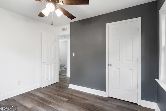 unfurnished bedroom featuring ceiling fan and dark wood-type flooring