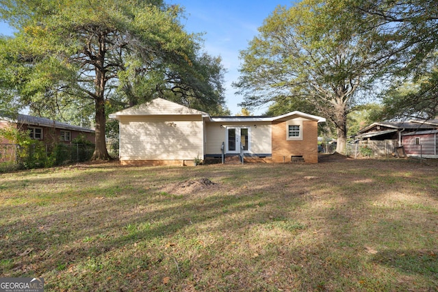 back of house featuring a yard and french doors